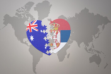 puzzle heart with the national flag of serbia and australia on a world map background. Concept.
