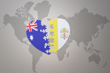 puzzle heart with the national flag of vatican city and australia on a world map background. Concept.