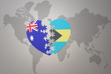 puzzle heart with the national flag of bahamas and australia on a world map background. Concept.