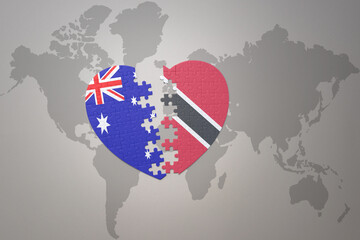 puzzle heart with the national flag of trinidad and tobago and australia on a world map background. Concept.