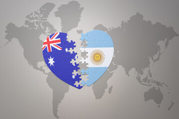 puzzle heart with the national flag of argentina and australia on a world map background. Concept.