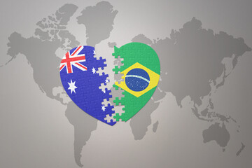 puzzle heart with the national flag of brazil and australia on a world map background. Concept.