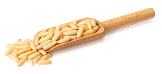 Roasted pine nuts in the wooden scoop, isolated on white background.