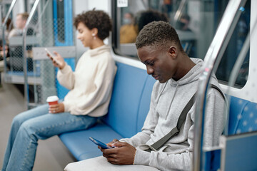 Obraz premium young people with smartphones traveling in the subway .