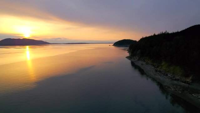 Aerial view of gorgeous sunset along Pacific Northwest coast. Drone footage of Larrabee Beach State Park near Bellingham, Washington at dusk.