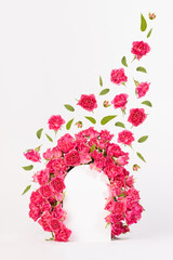 Fresh pink roses as framing of arch with green leaves and buds fly as swirl on abstract white scene mockup for presentation cosmetic products, goods, vertical. Summer template for advertising, design.