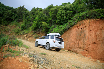 Fototapeta na wymiar Driving off road car in tropical forest mountains
