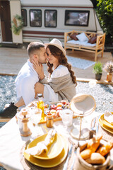 Beautiful wedding couple laugh and kiss relaxing in rv, camping in a trailer. Romantic moment. Together. Wedding. Marriage.