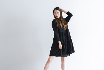 黒いワンピースを着たロングヘアの女性