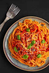 Homemade Spaghetti with Olives and Tomato Sauce on a Plate, top view. Flat lay, overhead, from above.