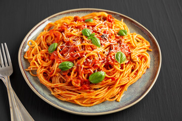 Homemade Spaghetti with Olives and Tomato Sauce on a Plate, side view. Close-up.