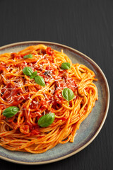 Homemade Spaghetti with Olives and Tomato Sauce on a Plate, side view.