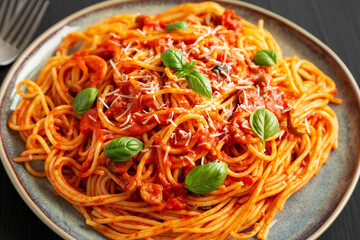 Homemade Spaghetti with Olives and Tomato Sauce on a Plate, side view.