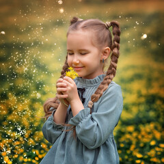 Portrait of a cute village girl kid with flower on a flower field. A child in a blooming meadow.