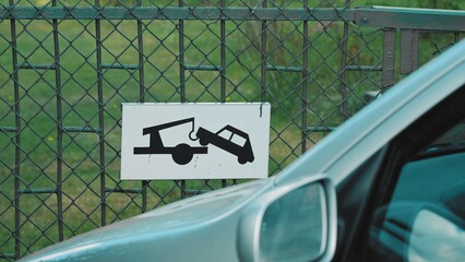 Vehicle Parked Illegally in front of Property Gate with Car Tow Away Caution Road Sign