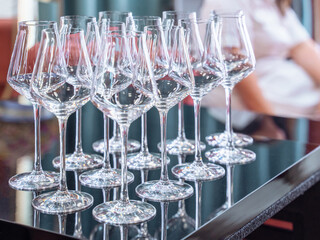 close up perspective of crystal clear empty wine glasses with slim stem on counter top bar 