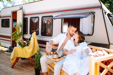 Beautiful wedding couple laugh and kiss relaxing in rv, camping in a trailer. Romantic moment....
