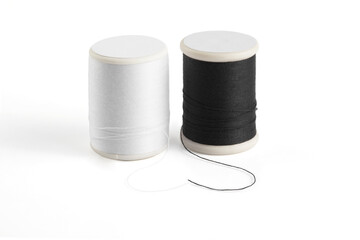 white and black sewing thread spool on a white