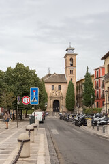 View at the St. Ana square with San Gil and Santa Ana Church, heritage colored buildings and Carrera del Darro to the street sad walk in Granada, Spain