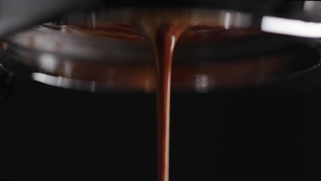 Slow motion macro shot of pulling espresso shot with bottomless portafilter