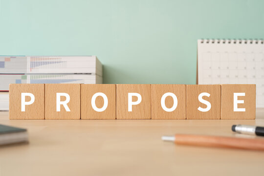 提案・プロポーズのイメージ｜「PROPOSE」と書かれた積み木が置かれたデスク