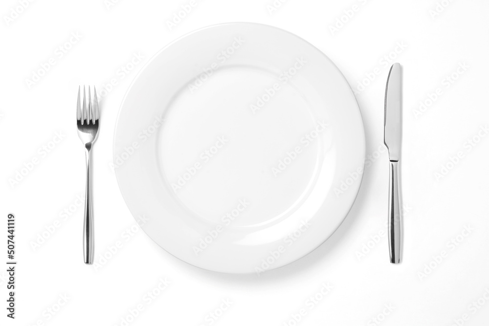 Wall mural empty plate with knife and fork isolated on a white background.