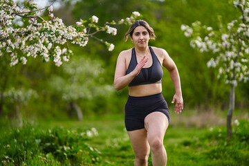 Plus size lady running through an orchard