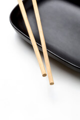 wooden chopsticks on black oval plate