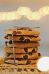 Christmas oatmeal cookies, biscuits on a light background with a beautiful bokeh from a garland. Abstract texture. New Year morning, breakfast. Food.