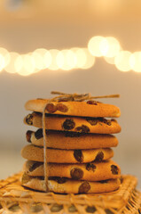 Christmas oatmeal cookies, biscuits on a light background with a beautiful bokeh from a garland. Abstract texture. New Year morning, breakfast. Food.