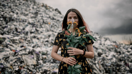 Girl in a garbage dump with flowers and in an oxygen mask, environmental disaster