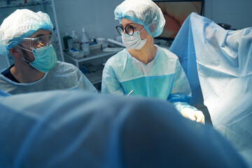 Nurse and doctor exchanging looks during surgical procedure