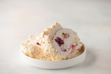 Homemade Meringue Cake Sweets Roll with Cherry jam on ceramic plate.