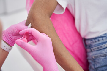 Doctor makes injection with small syringe into elbow of woman