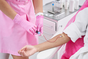 Woman in medical institution is injected with blood plasma intravenously