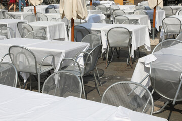 chairs and tables without customers in the alfresco restaurante in the square of European city during the economic crisis caused by the coronavirus lockdowns