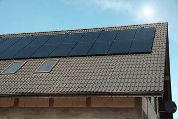 House with installed solar panels on roof. Alternative energy