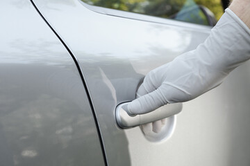 Closeup view of man in glove opening car door
