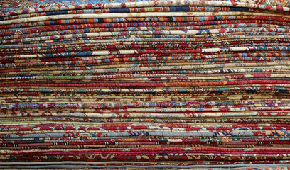 background of many oriental carpets made of wool for sale in the shop of precious carpets