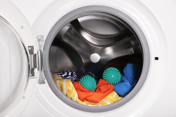 Green dryer balls and clothes in washing machine drum