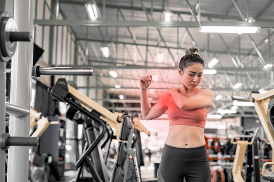 Woman has injury and hurt at arms while workout and weight training at gym, muscle pain concept