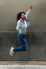 Happy asian woman jumping in the street