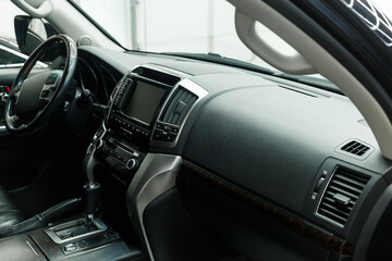 The interior of a modern car in close-up. Car interior - steering wheel, gear shift lever, multi...
