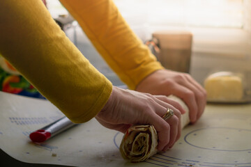 A close-up of a woman preparing some empanadas in her kitchen