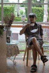 person one sitting on a bench in the coffee shop and comfortably holding a cup of coffee, Portrait.
