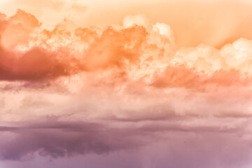 Twilight sky with effect of light pastel orange colors. Colorful sunset of soft clouds.