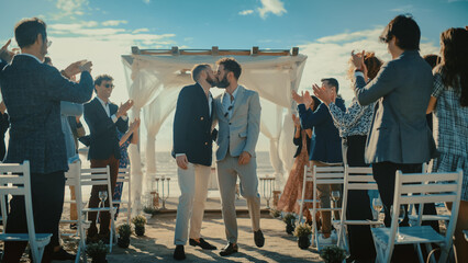 Handsome Gay Couple Walking Up the Aisle at Outdoors Wedding Ceremony Venue Near Ocean. Two Happy...