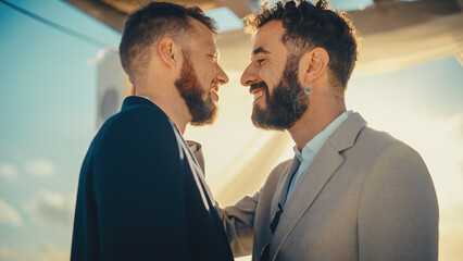 Close Up of Handsome Gay Couple Exchange Rings and Kiss at Outdoors Wedding Ceremony Venue Near the Sea. Two Happy Men in Love Share Their Vows and Get Married. LGBTQ Relationship Goals.