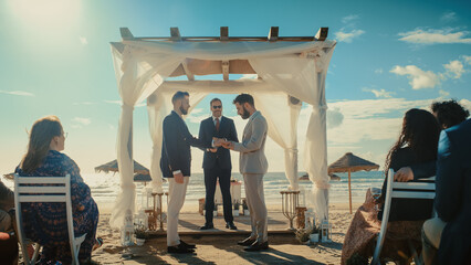 Handsome Gay Couple Exchange Rings and Kiss at Outdoors Wedding Ceremony Venue Near the Sea. Two...