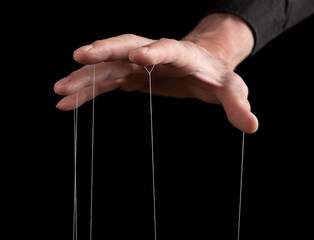 Authority, domination concept. Man hand with strings on fingers. Master, abuser using power to...
